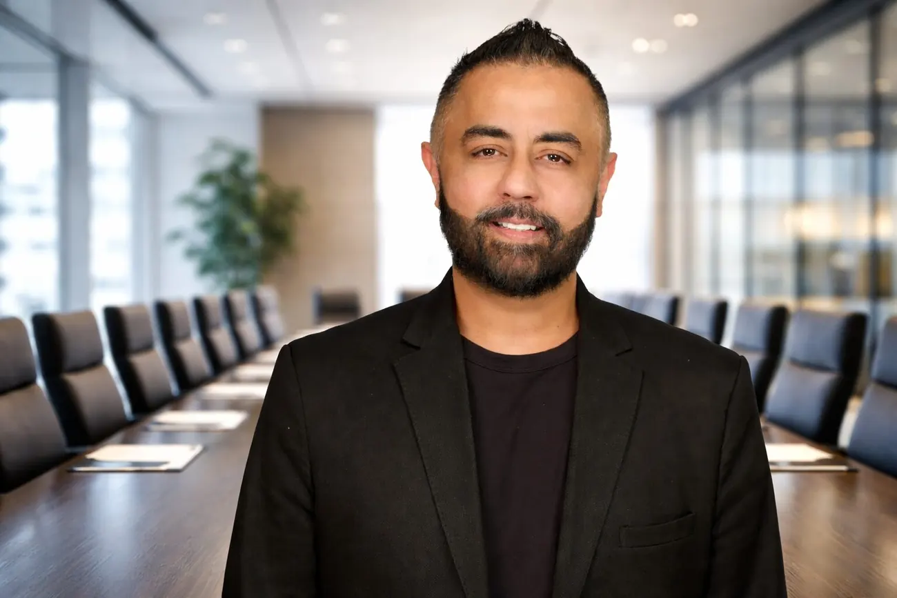 Omer Qureshi photographed in a corporate boardroom.