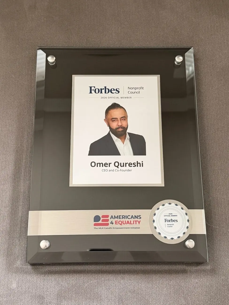 Forbes Nonprofit Council 2026 Official Member plaque awarded to Omer Qureshi.